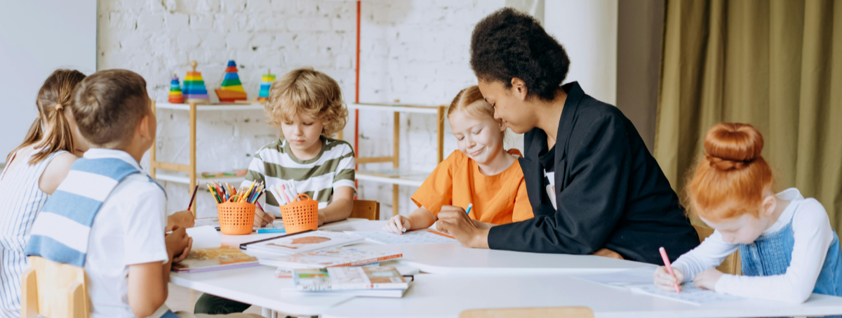 A woman teaching a group of students at a table